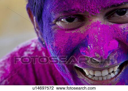 Stock Image - Man's face covered in holi colours. Fotosearch