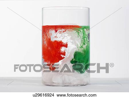 Picture - Paints dissolving in a glass. Fotosearch
