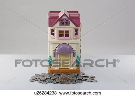 Toy house and coins View Large Photo Image Stock Photo - Toy house and coins. Fotosearch