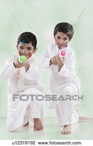 Stock Image - Two boys playing with pichkaris. Fotosearch