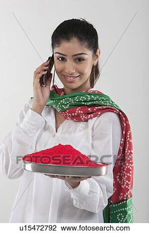 Stock Image - Woman holding a tray of colours while talking on the mobile phone. Fotosearch