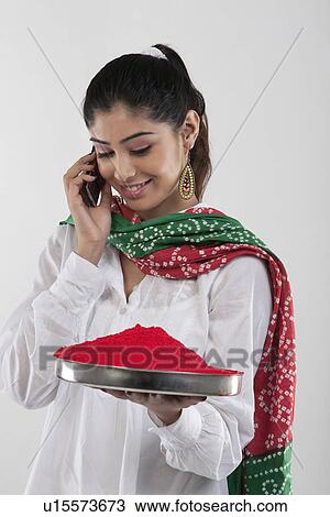 Stock Image - Woman holding a tray of colours while talking on the mobile phone. Fotosearch