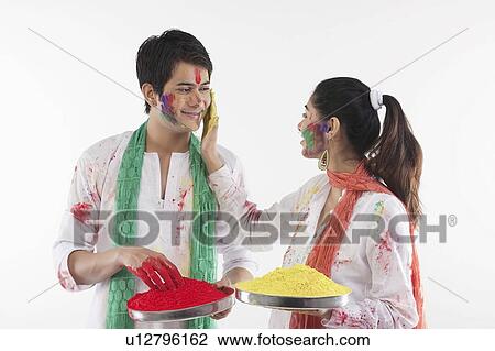 Stock Image - Woman putting colour on a man's face. Fotosearch