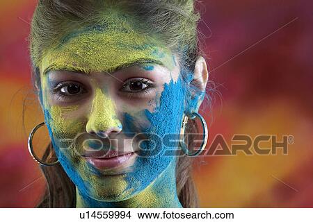 Picture - Woman's face covered in holi colours. Fotosearch