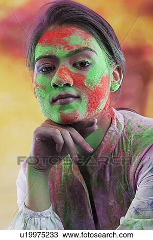Stock Image - Woman's face covered in holi colours. Fotosearch