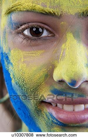 Stock Photo - Woman's face covered in holi colours. Fotosearch