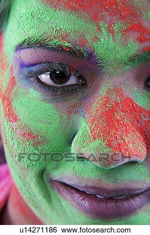 Stock Photograph - Woman's face covered in holi colours. Fotosearch