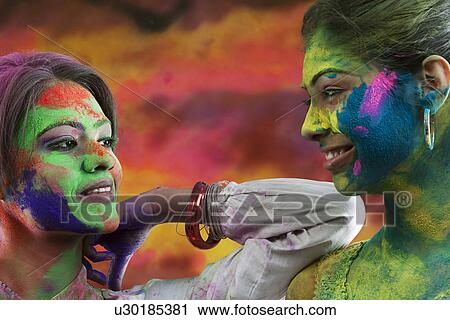 Stock Image - Women covered in holi colours. Fotosearch