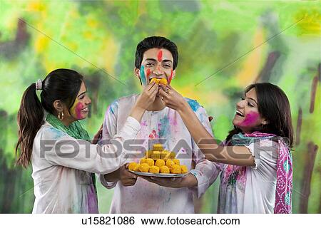 Women feeding a man laddoos View Large Photo Image Stock Photograph - Women feeding a man laddoos. Fotosearch