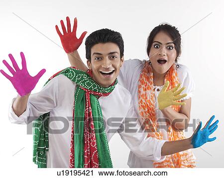 Stock Image - Young couple with coloured palms. Fotosearch