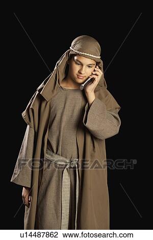 Stock Image - boy depicting jesus holding a cellphone. Fotosearch
