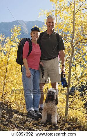 Couple hiking with a dog in a mountains in the autumn View Large Photo Image Stock Image - Couple hiking with a dog in a mountains in the autumn. Fotosearch