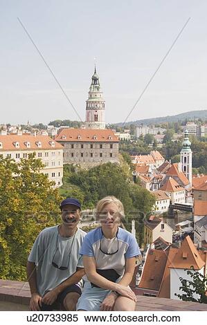 Stock Photography - Couple sitting with Krumlov Chateau and Round Tower in background. Fotosearch