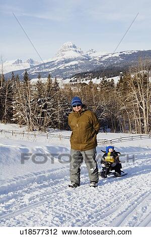 Father pulling son on sled in the winter View Large Photo Image Stock Image - Father pulling son on sled in the winter. Fotosearch