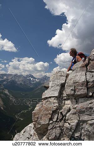 Man sitting on a mountain top enjoying the view View Large Photo Image Stock Image - Man sitting on a mountain top enjoying the view. Fotosearch