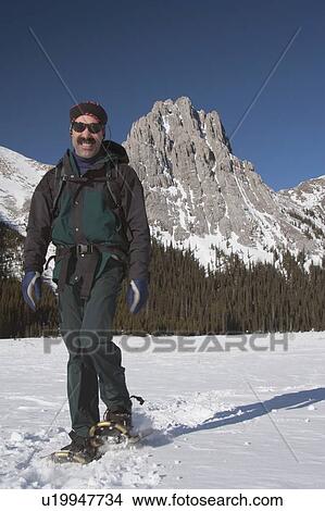 Picture - Man walking in snowshoes in the mountains. Fotosearch