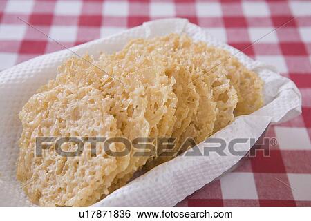 Stock Photograph - parmesan cheese laces in a basket on a red checkered table cloth. Fotosearch