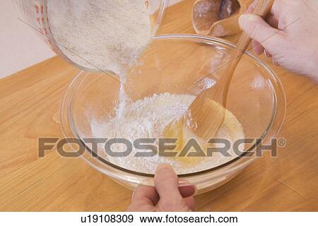 Stock Photo - person mixing ingredients into a bowl. Fotosearch