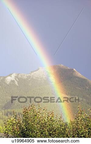 Stock Photography - Rainbow over mountains, Jasper National Park, Alberta, Canada. Fotosearch