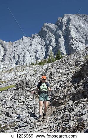 Stock Photo - Woman hiking on a mountain path. Fotosearch
