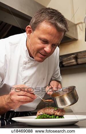 Chef Adding Sauce To Dish In Restaurant Kitchen View Large Photo Image Stock Photo - Chef Adding Sauce To Dish In Restaurant Kitchen. Fotosearch