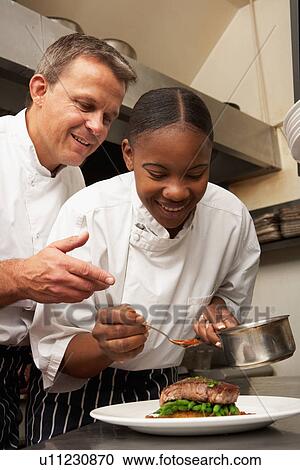 Chef Instructing Trainee In Restaurant Kitchen View Large Photo Image Stock Image - Chef Instructing Trainee In Restaurant Kitchen. Fotosearch