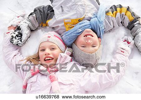 Stock Photo - Children Laying On Ground Making Snow Angel. Fotosearch
