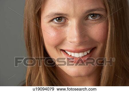 Stock Photo - Close Up Studio Portrait Of Smiling Young Woman. Fotosearch