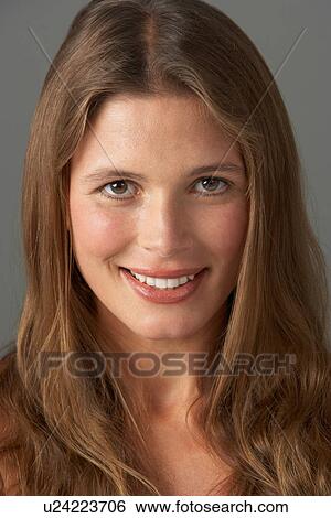 Stock Photograph - Close Up Studio Portrait Of Smiling Young Woman. Fotosearch