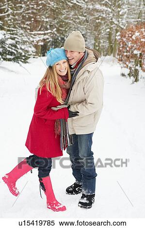 Stock Photography - Couple Walking Through Snowy Woodland. Fotosearch