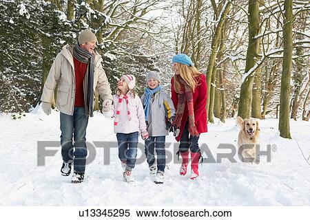 Stock Photography - Family Walking Dog Through Snowy Woodland. Fotosearch
