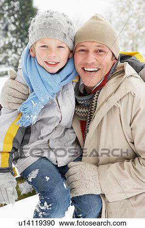 Stock Image - Father And Son Standing Outside In Snowy Landscape. Fotosearch