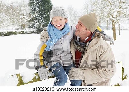 Stock Photograph - Father And Son Standing Outside In Snowy Landscape. Fotosearch