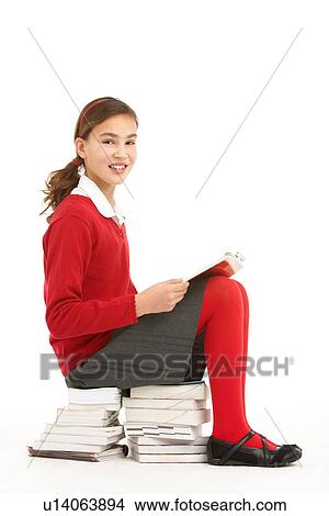 Female Student In Uniform Sitting On Pile Of Books Reading View Large Photo Image Picture - Female Student In Uniform Sitting On Pile Of Books Reading. Fotosearch