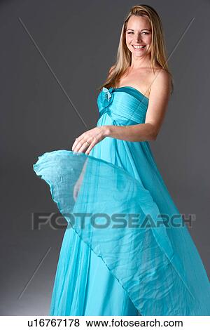 Stock Photo - Full Length Studio Shot Of Young Woman In Blue Evening Dress. Fotosearch
