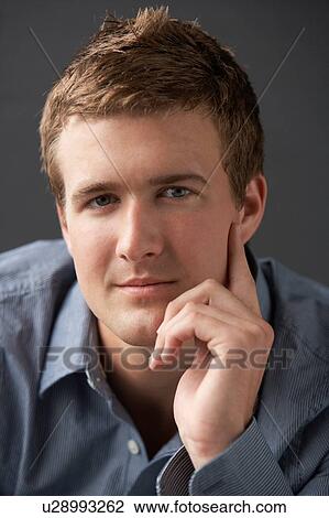 Stock Image - Head And Shoulders Portrait Of Young Man In Studio. Fotosearch