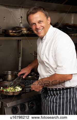 Male Chef Preparing Meal On Cooker In Restaurant Kitchen View Large Photo Image Stock Image - Male Chef Preparing Meal On Cooker In Restaurant Kitchen. Fotosearch