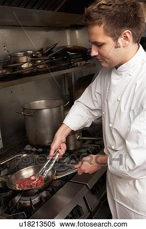 Male Chef Preparing Meal On Cooker In Restaurant Kitchen View Large Photo Image Stock Photography - Male Chef Preparing Meal On Cooker In Restaurant Kitchen. Fotosearch