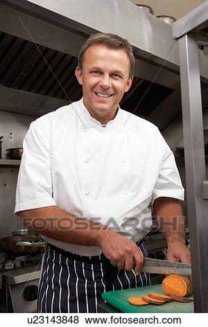 Stock Photo - Male Chef Preparing Vegetables In Restaurant Kitchen. Fotosearch