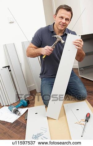 Stock Photo - Man Assembling Flat Pack Furniture. Fotosearch