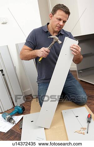 Stock Photography - Man Assembling Flat Pack Furniture. Fotosearch