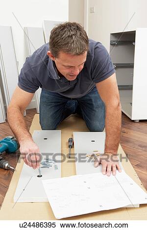 Stock Photography - Man Assembling Flat Pack Furniture. Fotosearch