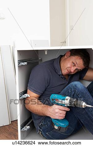 Man Trapped Whilst Assembling Flat Pack Furniture View Large Photo Image Picture - Man Trapped Whilst Assembling Flat Pack Furniture. Fotosearch