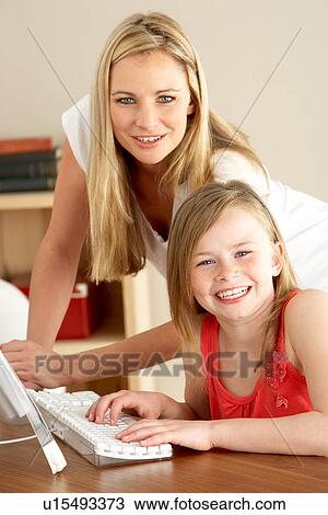 Stock Image - Mother And Daughter At Home Using Computer. Fotosearch