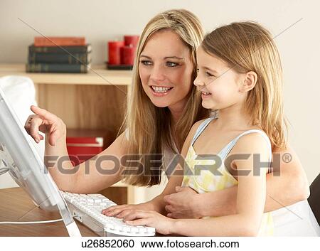 Stock Image - Mother And Daughter At Home Using Computer. Fotosearch