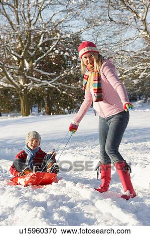 Mother Pulling Son On Sledge Through Snowy Landscape View Large Photo Image Stock Image - Mother Pulling Son On Sledge Through Snowy Landscape. Fotosearch