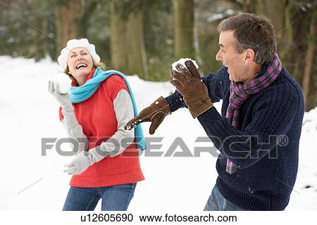 Senior Couple Having Snowball Fight In Snowy Woodland View Large Photo Image Stock Image - Senior Couple Having Snowball Fight In Snowy Woodland. Fotosearch