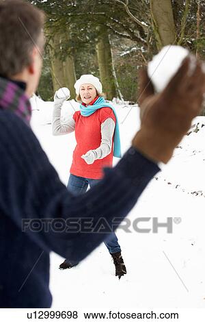 Senior Couple Having Snowball Fight In Snowy Woodland View Large Photo Image Stock Photo - Senior Couple Having Snowball Fight In Snowy Woodland. Fotosearch