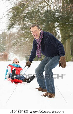 Senior Couple Sledging Through Snowy Woodland View Large Photo Image Stock Image - Senior Couple Sledging Through Snowy Woodland. Fotosearch