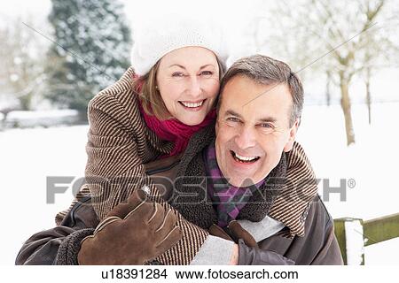 Picture - Senior Couple Standing Outside In Snowy Landscape. Fotosearch